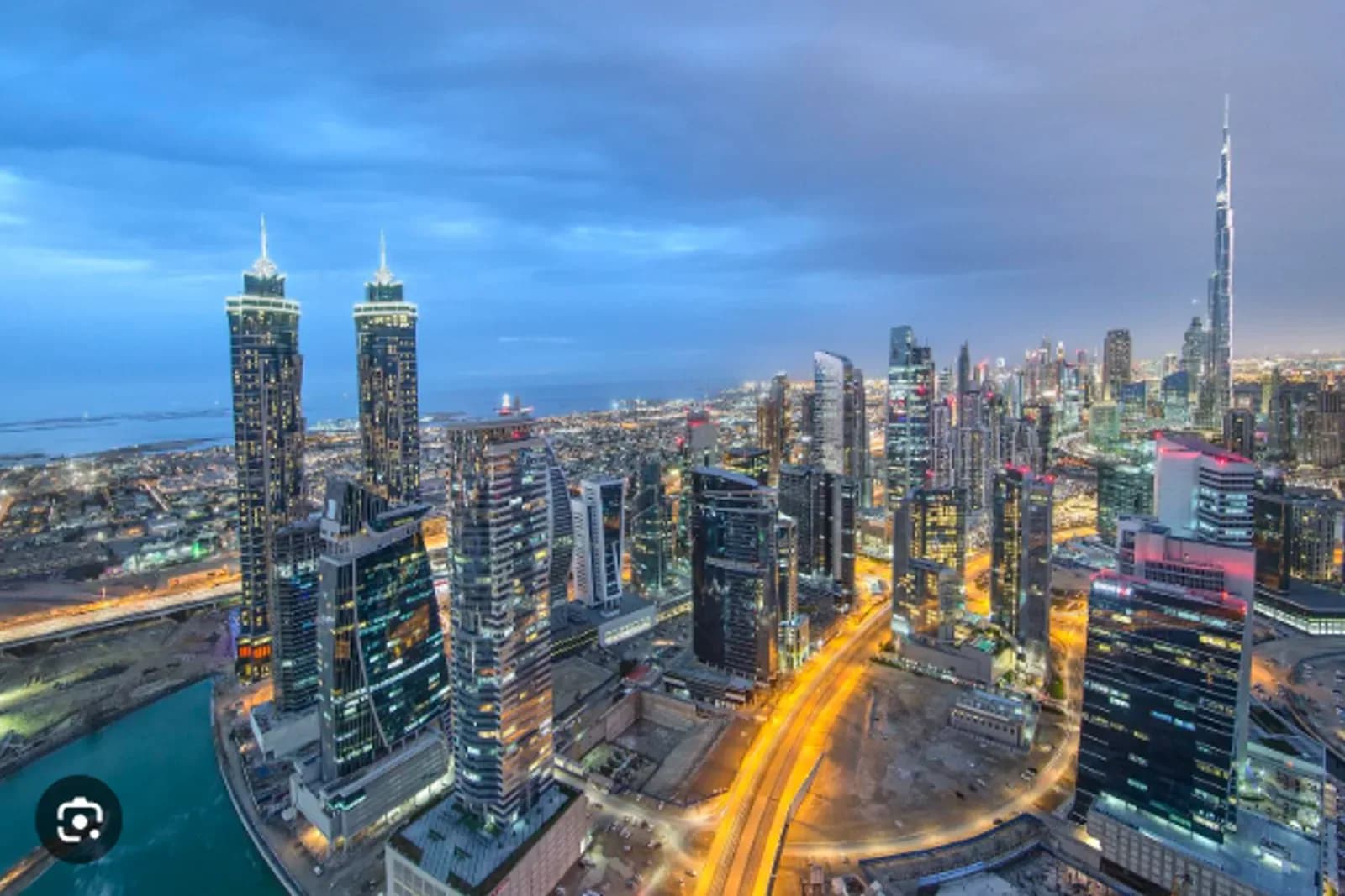 Business Bay skyline and canal at dusk with Burj Khalifa in the background