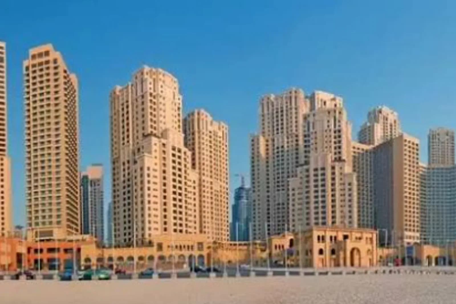 JBR's beachfront tower cluster viewed from the sand at golden hour